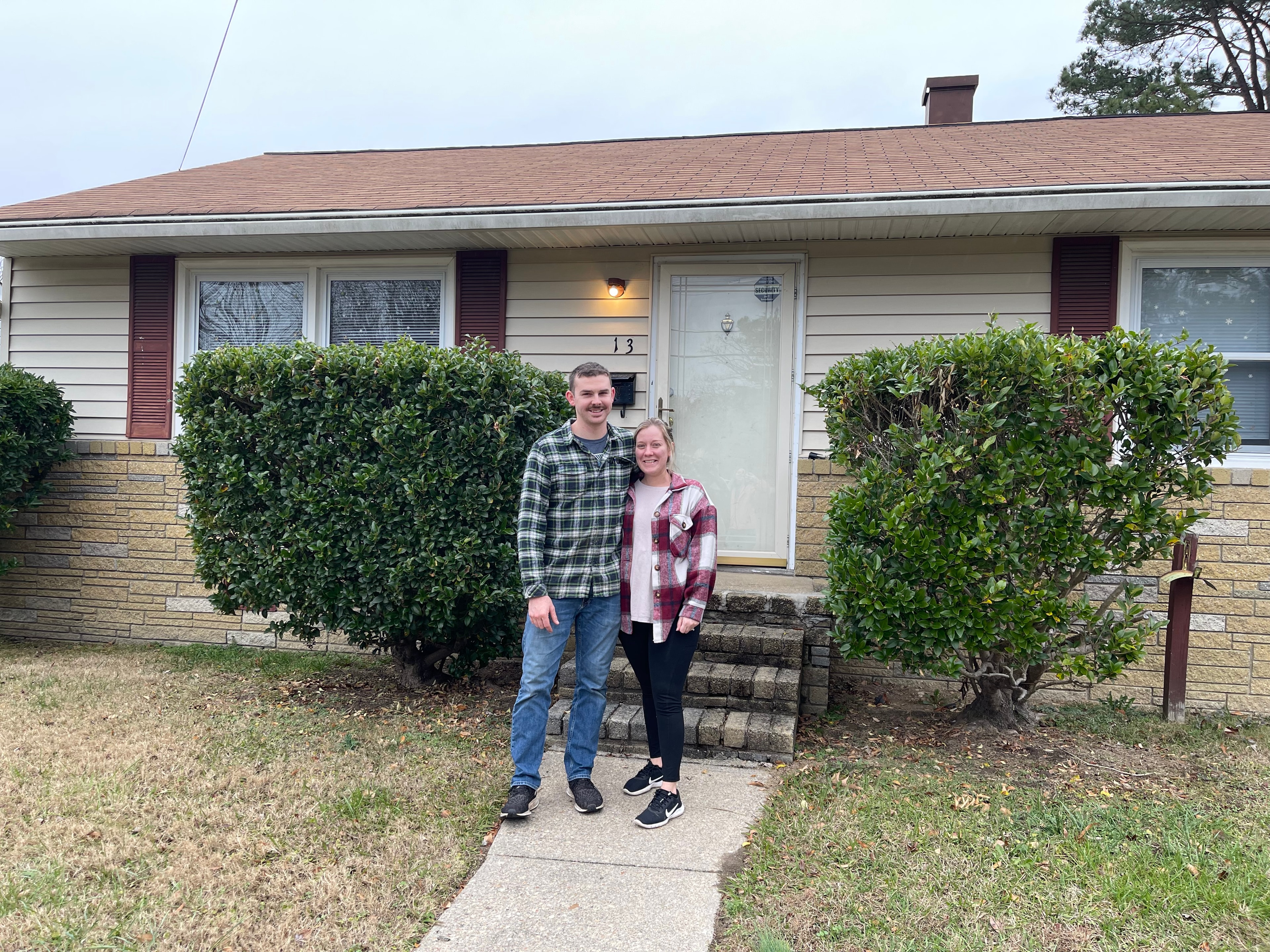 New homeowners in front of their house